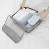 Hands are shown packing clothes into a set of packing cubes. Voir les images du produit
