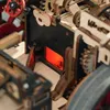 A close-up view of a detailed wooden mechanical model, possibly a steam engine or a complex machine, with a glowing red interior. Voir les images du produit