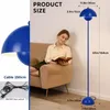 A woman is reading a book next to a blue floor lamp. The image also shows product dimensions and cable details. Produktbild-Vorschau