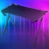 A gaming desk with RGB lighting in a dark room. Voir les images du produit