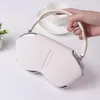 A hand holding a white AirPods Max case over a white surface. Podgląd zdjęcia produktu