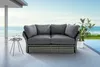 An outdoor sofa set with a table and plant next to a pool with the ocean in the background. Produktbild-Vorschau
