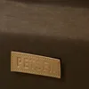 A close-up of a brown fabric surface with a tan leather label attached. Náhled obrázku produktu