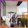 A cat sits on a cat tree on a balcony with outdoor furniture and plants. Náhľad obrázku produktu
