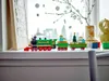 A LEGO Christmas train set displayed on a windowsill with a wintery background. Produktbild-Vorschau