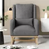 A gray teddy plush rocking chair with a pillow and a small lumbar pillow, placed in a living room setting with a side table and a cabinet. Produktbild-Vorschau