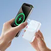 A person is holding a smartphone and a white wireless power bank, demonstrating the magnetic charging feature. Podgląd zdjęcia produktu