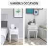 Two images of a white nightstand, one next to a bed and the other in a living room setting. Produktbild-Vorschau