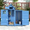 A blue wooden garden shed with tools and gardening supplies inside, set on a patio. Voir les images du produit