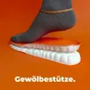 Grauer Sockenfuß, der auf eine orange-weiße Einlegesohle drückt, mit Text 'Fußgewölbeunterstützung' Produktbild-Vorschau