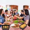 A family is gathered around a table, enjoying a meal and toasting with wine. Produktbild-Vorschau