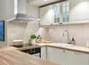 A modern kitchen with a stainless steel range hood over a stovetop and sink. Produktbild-Vorschau