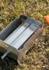 A metal smoking tray sits on the ground with grass and dirt. Produktbild-Vorschau