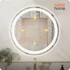 A round LED mirror in a bathroom setting, showing condensation and illuminated arrows indicating anti-fog feature. Podgląd zdjęcia produktu