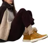 A person sitting down wearing a sweater and boots. Produktbild-Vorschau