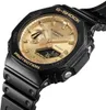 A close-up, angled shot of a black and gold Casio G-Shock watch against a white background. Produktbild-Vorschau