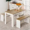 A dining table and two benches are set up in a room with a white cabinet and a plant in the background. Náhled obrázku produktu