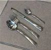 A set of silverware laid out on a textured surface. Voir les images du produit