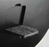 A close-up view of a small, textured gray pad attached to a black object. Produktbild-Vorschau