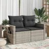 A two-seater outdoor sofa with dark gray cushions, placed on a rug on a patio, with plants in the background. Podgląd zdjęcia produktu