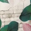 A close-up view of a textured surface resembling a brick wall, overlaid with large, stylized leaves in various colors. Produktbild-Vorschau