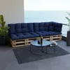 A dark blue pallet sofa with cushions on a balcony overlooking the ocean. Anteprima dell’immagine prodotto