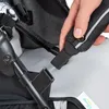 A hand is shown connecting a part of a stroller harness. Anteprima dell’immagine prodotto