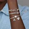 A close-up shot of a person's arm wearing multiple Pandora charm bracelets, showcasing different charms. Produktbild-Vorschau