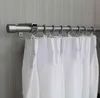 A close-up view of a brushed stainless steel curtain rod with white curtains attached. Produktbild-Vorschau