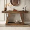 A wooden console table with decorative items on and under it, placed against a wall with decorative molding. Produktbild-Vorschau