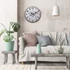 A living room scene with a clock on the wall, a sofa with cushions, and a coffee table with decorative items. Anteprima dell’immagine prodotto