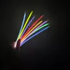 A hand holding a fan of colorful glow sticks against a black background. Anteprima dell’immagine prodotto