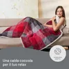 A woman is relaxing on a couch, covered by a plaid blanket. Anteprima dell’immagine prodotto
