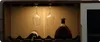 A close-up view of a wine cabinet interior, showcasing two wine glasses hanging upside down, a bottle of wine on a rack, and a large bottle of liquor. Podgląd zdjęcia produktu