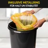 Hands are shown inserting a yellow trash bag with an orange rim into a black trash can. A metal ring is visible around the top of the trash bag. Produktbild-Vorschau