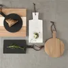 Several cutting boards of different materials and shapes are arranged on a gray textured surface. Produktbild-Vorschau