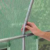 A hand is shown connecting two metal poles of a greenhouse frame, with the green transparent PE cover visible. Produktbild-Vorschau