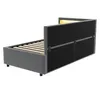 A back-side view of a gray upholstered bed frame with wooden slats and LED lighting at the headboard. Voir les images du produit