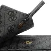 A close-up view of a grey handbag with a repeating logo pattern and metallic snap closures. Podgląd zdjęcia produktu