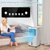 A woman is sitting on a couch and operating a portable air cooler with a remote control. Produktbild-Vorschau