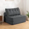A gray foldable sofa bed is shown in a room with a wooden floor and a white wall. Náhled obrázku produktu