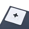 A close-up view of the back of a dark gray rectangular object, showing a white square mounting bracket with a cross-shaped cutout. Podgląd zdjęcia produktu