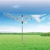 A rotary clothesline stands in a grassy field under a blue sky with some clouds. A white garment is hanging on one of the lines. Anteprima dell’immagine prodotto