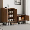 A wooden shoe cabinet with a built-in bench, displaying various shoes and a box inside. Produktbild-Vorschau
