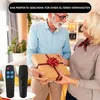 An older couple exchanging a gift, with two remote controls in the foreground. Produktbild-Vorschau