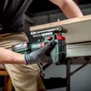 A person is using a Metabo cordless jigsaw to cut a piece of wood. Voir les images du produit