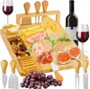 A cheese board set with various cheeses, fruits, nuts, crackers, honey, wine, and cheese knives, arranged on a wooden board. Náhľad obrázku produktu
