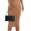 A person is holding a black clutch bag in front of a tan dress. Produktbild-Vorschau