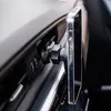 A smartphone holder attached to a car's air vent, holding a clear-cased smartphone. Náhled obrázku produktu