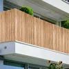 A close-up view of a bamboo privacy screen on a balcony, with a small green bush visible at the top. Produktbild-Vorschau